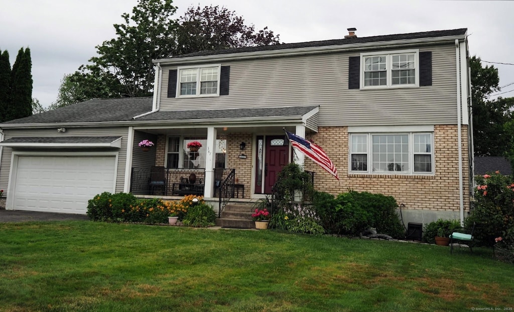347 Shingle Hill Rd, West Haven, CT 06516 - traditional home featuring covered porch, brick siding, an attached garage, and a front yard