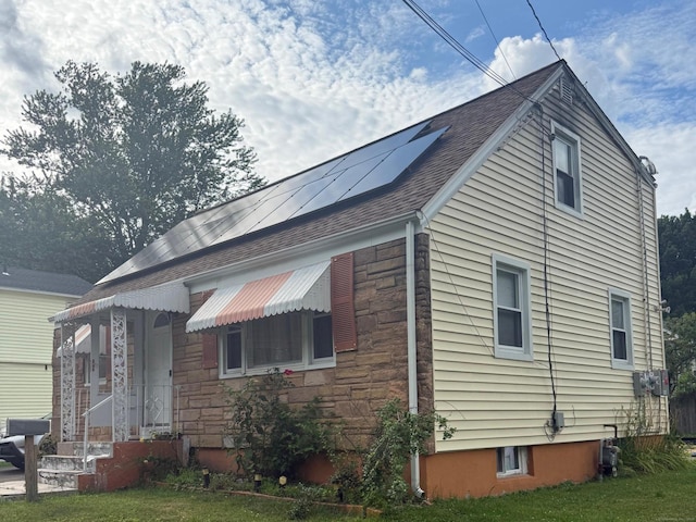 34 Gilbert Ave, Bloomfield, CT 06002 - view of property exterior with solar panels, stone siding, and a shingled roof