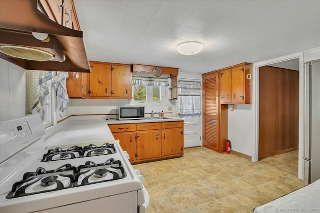 496 Mulberry St, Southington, CT 06479 - kitchen with stainless steel appliances, exhaust hood, light countertops, and brown cabinets