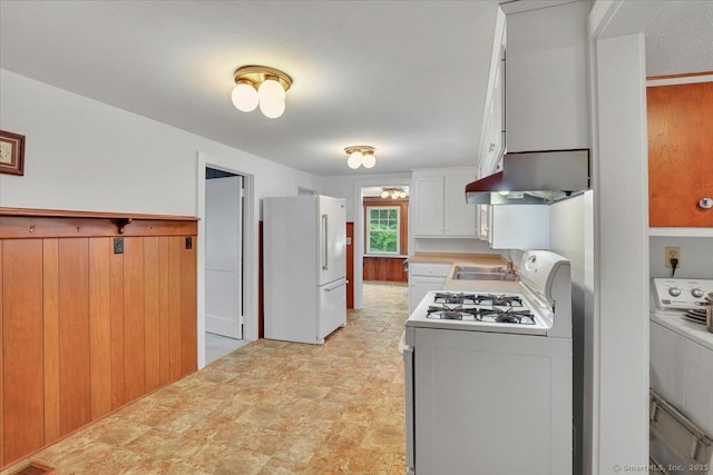496 Mulberry St, Southington, CT 06479 - kitchen featuring white appliances, washer / dryer, exhaust hood, light countertops, and wooden walls