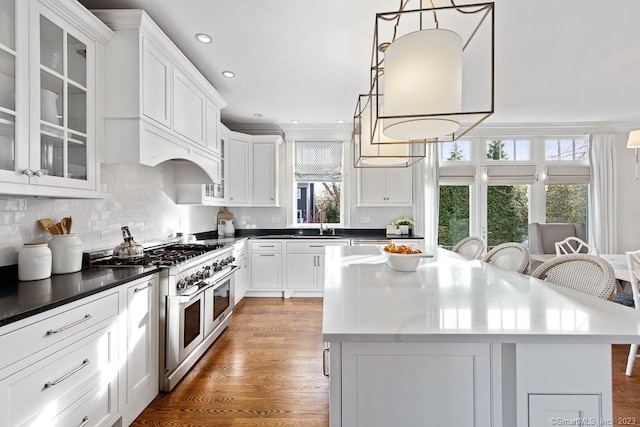 81 Birch Rd, Fairfield, CT 06824 - kitchen featuring range with two ovens, a center island, white cabinetry, tasteful backsplash, and glass insert cabinets
