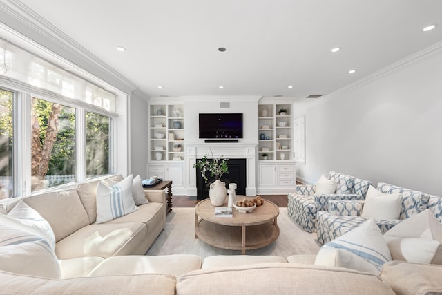 81 Birch Rd, Fairfield, CT 06824 - living area with wood finished floors, crown molding, a fireplace, recessed lighting, and built in shelves