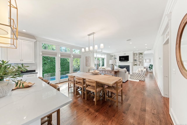 81 Birch Rd, Fairfield, CT 06824 - dining room featuring a fireplace, wood finished floors, built in shelves, recessed lighting, and a chandelier