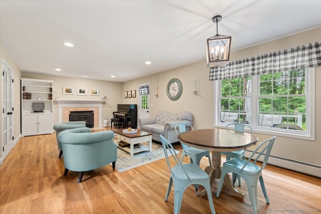 26 Philo Curtis Rd, Newtown, CT 06482 - dining space featuring baseboard heating, light wood finished floors, a tiled fireplace, recessed lighting, and a chandelier