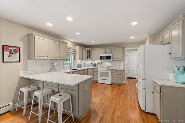 26 Philo Curtis Rd, Newtown, CT 06482 - kitchen featuring a peninsula, white appliances, decorative backsplash, a kitchen bar, and gray cabinetry