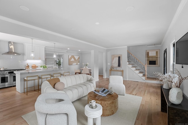 226 Ruane St, Fairfield, CT 06824 - living room with stairs, light wood-style floors, crown molding, and recessed lighting