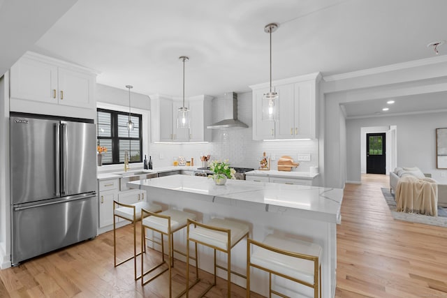 226 Ruane St, Fairfield, CT 06824 - kitchen featuring high end fridge, decorative backsplash, wall chimney exhaust hood, light wood-style flooring, and white cabinetry