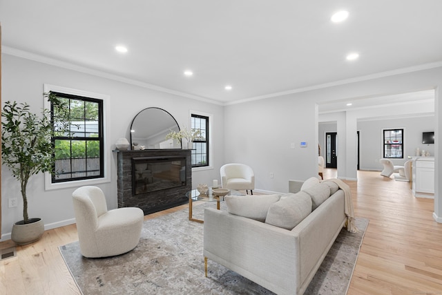 226 Ruane St, Fairfield, CT 06824 - living area with plenty of natural light, a glass covered fireplace, recessed lighting, light wood-style floors, and ornamental molding