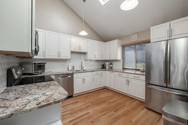 2289 Bedford St Unit F2, Stamford, CT 06905 - kitchen featuring appliances with stainless steel finishes, light stone countertops, backsplash, hanging light fixtures, and high vaulted ceiling