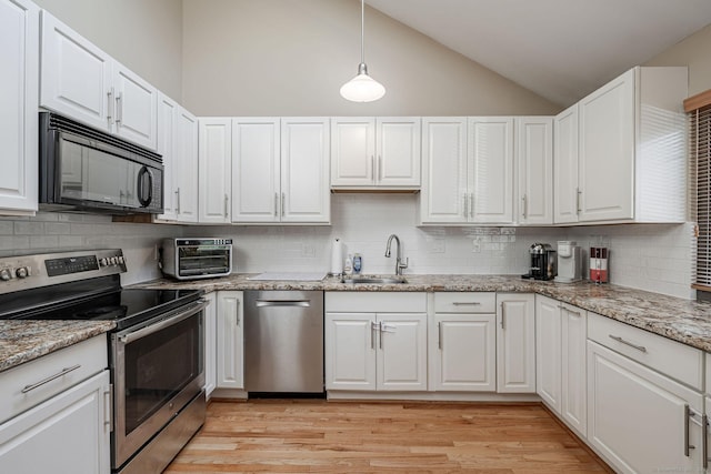 2289 Bedford St Unit F2, Stamford, CT 06905 - kitchen with appliances with stainless steel finishes, vaulted ceiling, decorative backsplash, and white cabinets
