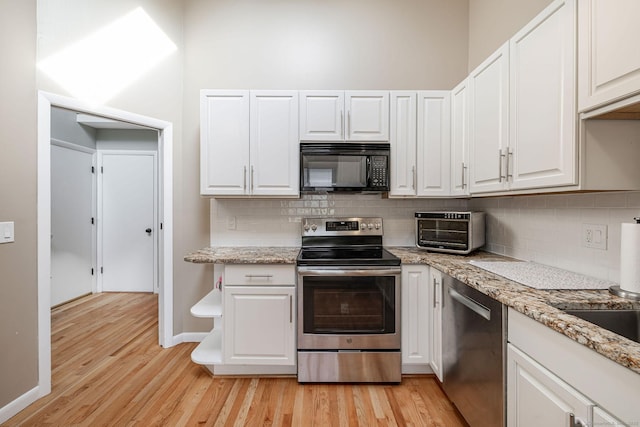 2289 Bedford St Unit F2, Stamford, CT 06905 - kitchen with stainless steel appliances, light wood-style flooring, white cabinetry, backsplash, and light stone countertops