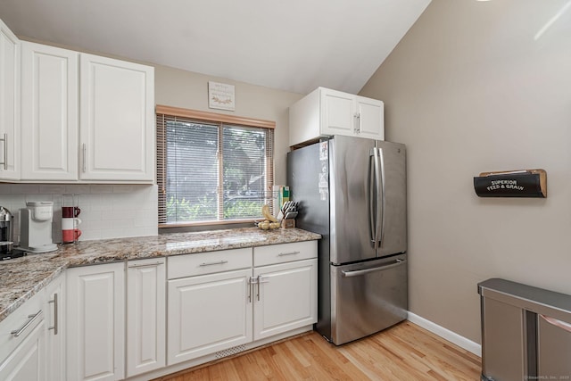 2289 Bedford St Unit F2, Stamford, CT 06905 - kitchen with freestanding refrigerator, light wood finished floors, backsplash, white cabinetry, and light stone countertops