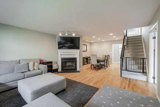 2289 Bedford St Unit F2, Stamford, CT 06905 - living area with wood finished floors, stairs, a fireplace with flush hearth, and rail lighting