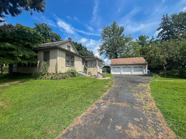 130 Wilkins Ave, Bridgeport, CT 06606 - view of front facade with an outbuilding, a chimney, a garage, and a front yard
