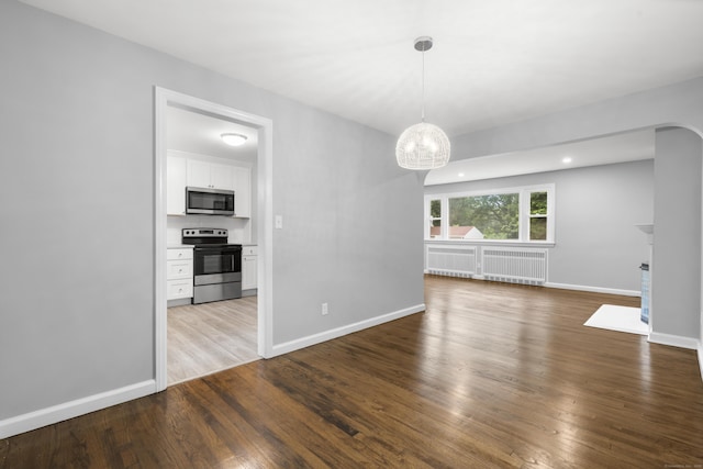 106 Lakeview Ave, West Haven, CT 06516 - unfurnished dining area with wood finished floors, radiator heating unit, a chandelier, and a fireplace