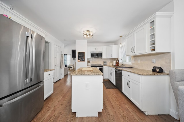 357 D Welton Way, Thomaston, CT 06787 - kitchen featuring stainless steel appliances, decorative backsplash, white cabinetry, a kitchen island, and wood finished floors