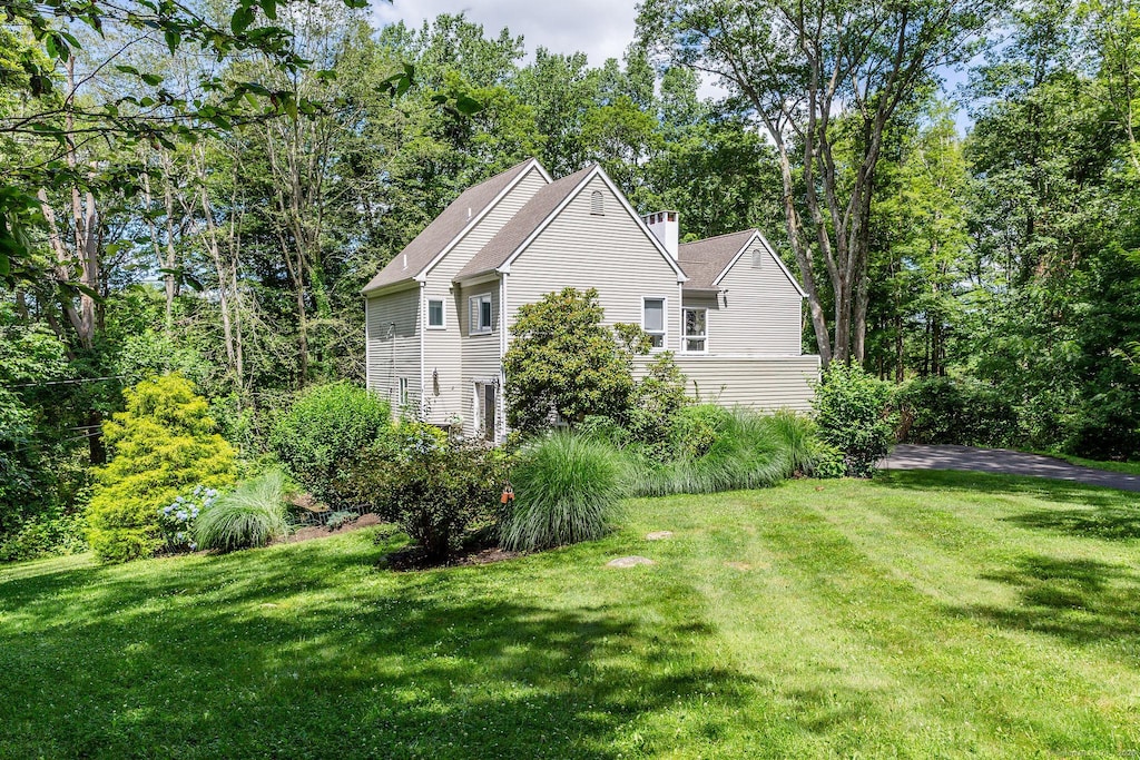48 Deer Hill Dr, Ridgefield, CT 06877 - view of home's exterior with a lawn and a chimney