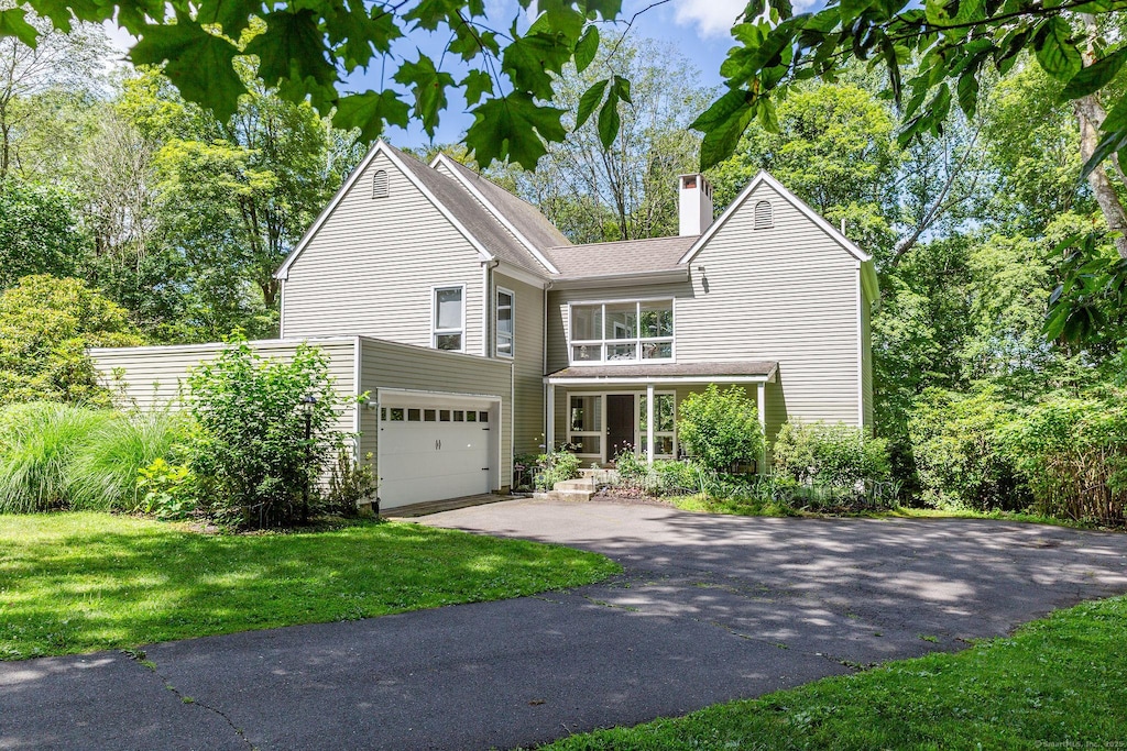 48 Deer Hill Dr, Ridgefield, CT 06877 - view of front facade with driveway, a chimney, a front yard, and a garage