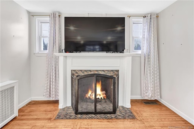 12 Sunset Ave, Trumbull, CT 06611 - detailed view of wood finished floors, radiator heating unit, and a lit fireplace