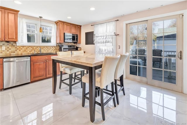 12 Sunset Ave, Trumbull, CT 06611 - kitchen with stainless steel appliances, decorative backsplash, brown cabinets, recessed lighting, and light marble finish floors