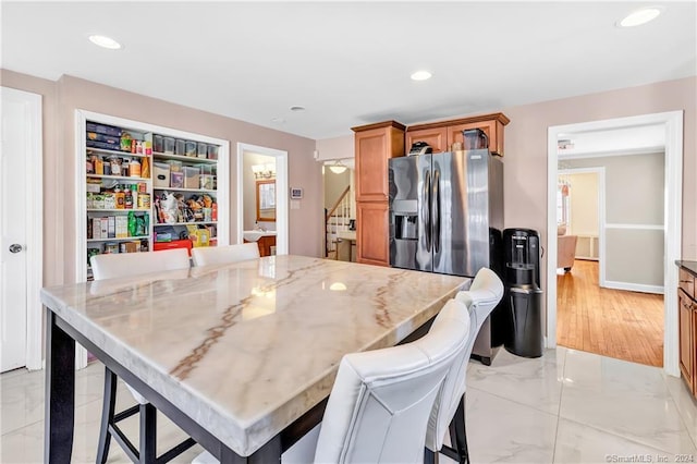 12 Sunset Ave, Trumbull, CT 06611 - kitchen with light marble finish floors, a center island, light stone counters, recessed lighting, and a breakfast bar area