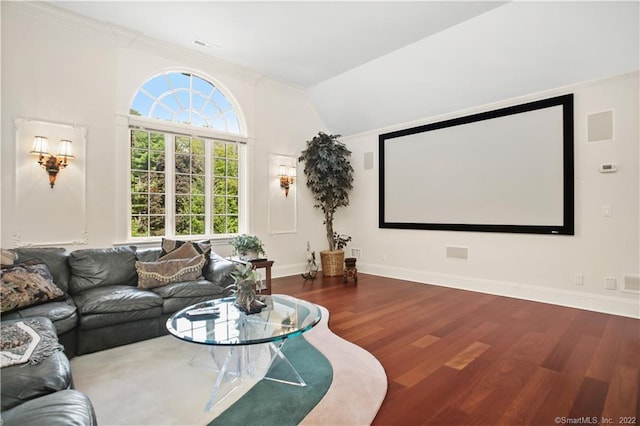 cinema room featuring ornamental molding and dark hardwood / wood-style floors