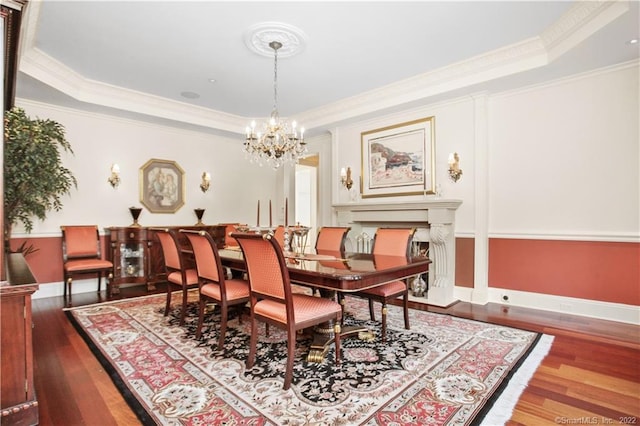 dining room featuring an inviting chandelier, dark wood-type flooring, ornamental molding, and a tray ceiling