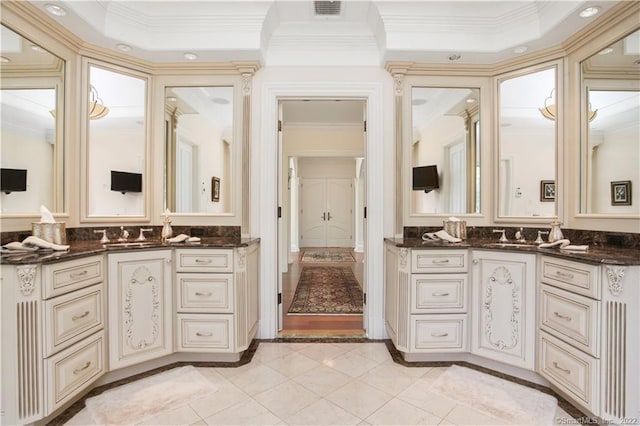 bathroom featuring a raised ceiling, double vanity, tile flooring, and ornamental molding