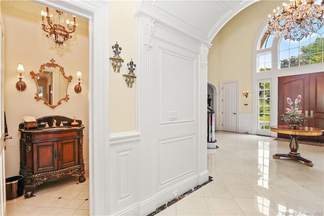 tiled foyer with a chandelier