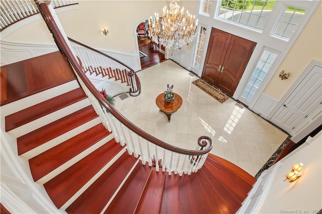 tiled entryway featuring an inviting chandelier and a towering ceiling