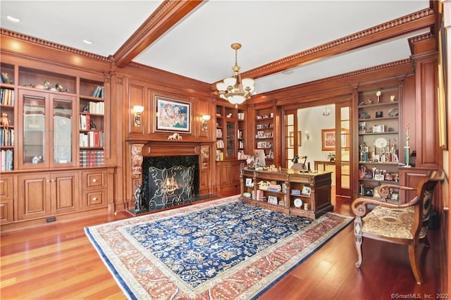 office area featuring a high end fireplace, built in features, a chandelier, and light hardwood / wood-style floors