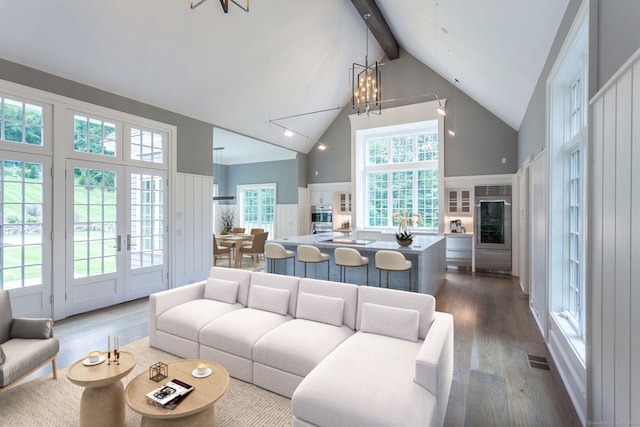 living area with dark wood-style floors, high vaulted ceiling, a wealth of natural light, and beam ceiling