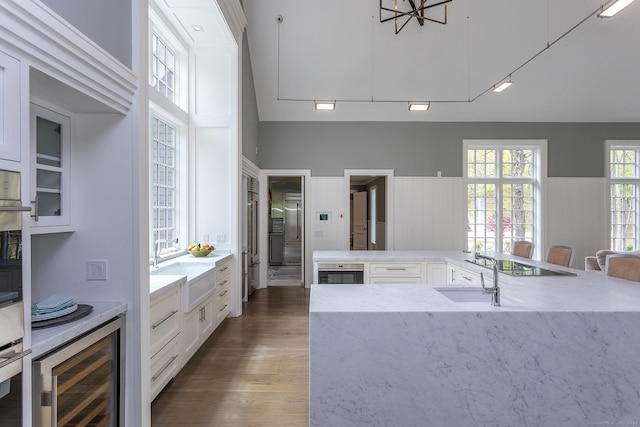 kitchen featuring white cabinets, dark wood-style flooring, a sink, and wine cooler