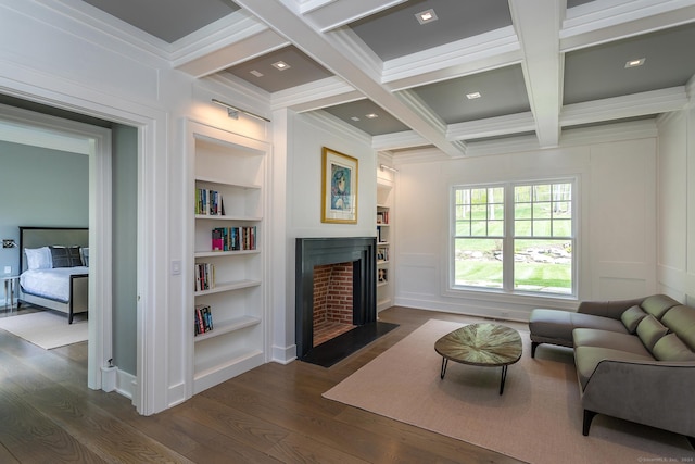 living room featuring beam ceiling, a decorative wall, a fireplace with flush hearth, and dark wood-style floors