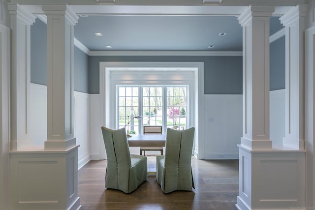 dining area with decorative columns, dark wood-style floors, wainscoting, and ornamental molding