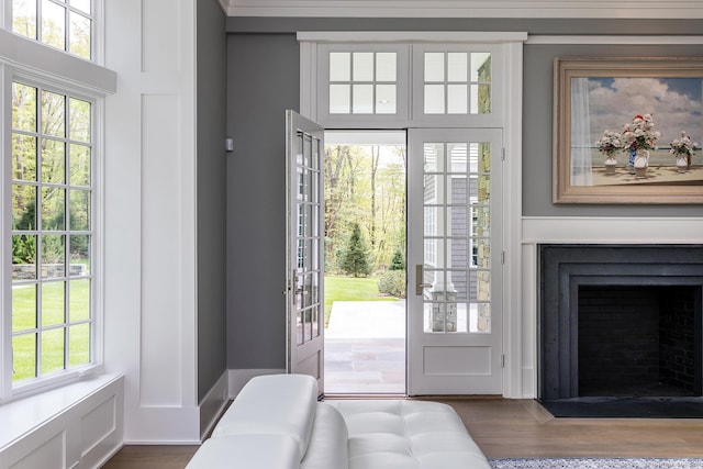 doorway featuring a fireplace with flush hearth and wood finished floors