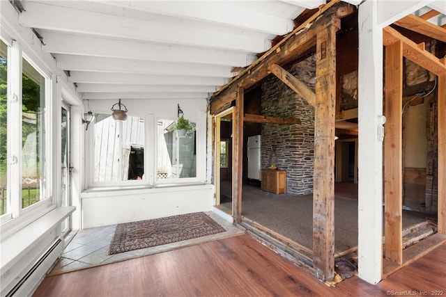 unfurnished sunroom with a baseboard radiator and vaulted ceiling with beams