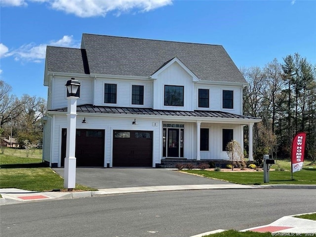 modern farmhouse style home featuring a front yard and a garage