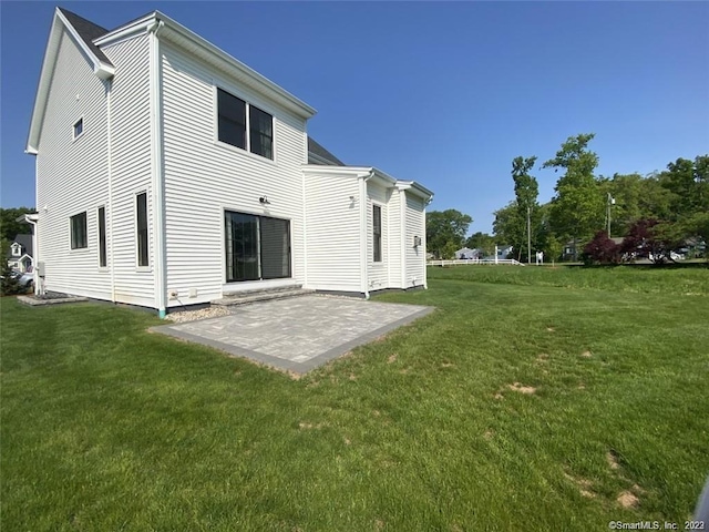 rear view of house featuring a lawn and a patio area