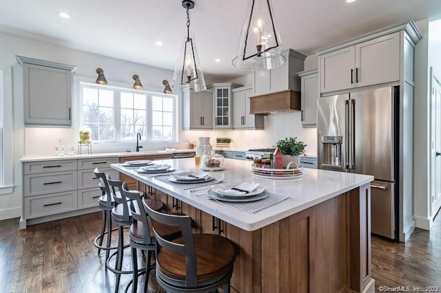 kitchen featuring pendant lighting, a center island, stainless steel appliances, sink, and dark hardwood / wood-style floors