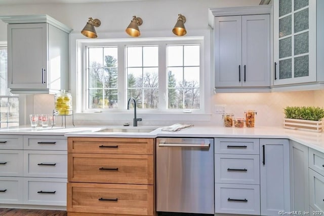 kitchen with white cabinetry, tasteful backsplash, dishwasher, and sink