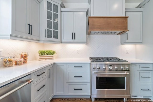 kitchen with custom exhaust hood, backsplash, dark hardwood / wood-style flooring, and stainless steel appliances