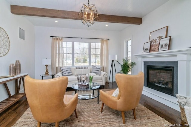 living area with an inviting chandelier, dark wood-type flooring, and beamed ceiling