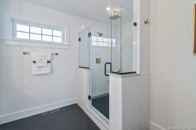 bathroom with tile flooring and a shower with door