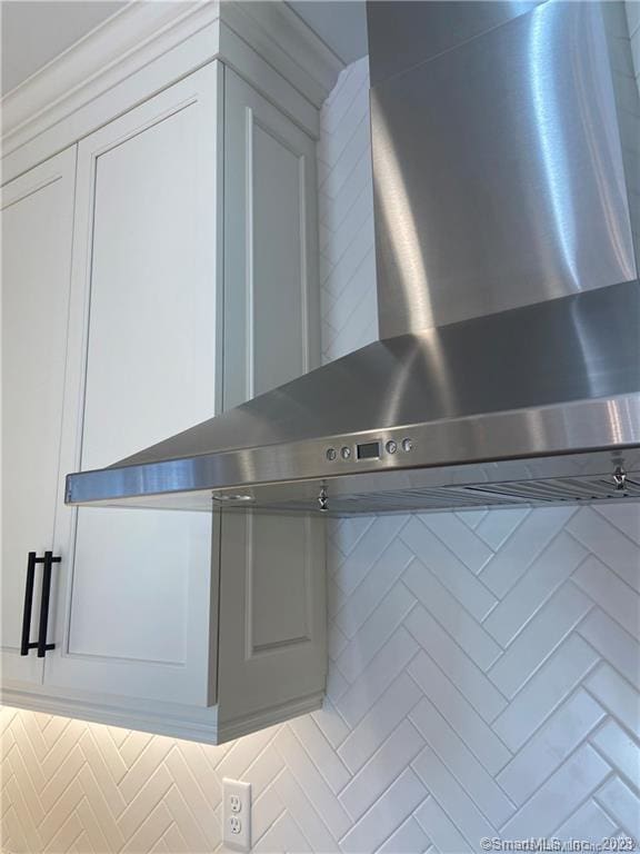 details with tasteful backsplash and wall chimney exhaust hood