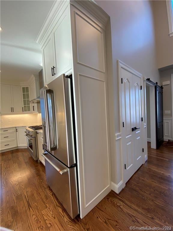 kitchen with premium appliances, dark hardwood / wood-style flooring, and white cabinets