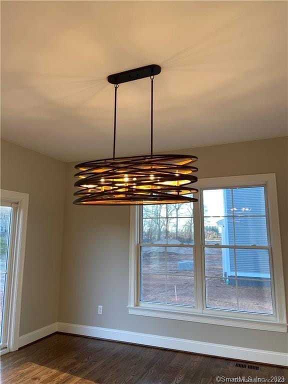 details with an inviting chandelier and dark hardwood / wood-style flooring