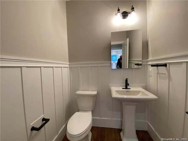 bathroom featuring wood-type flooring and toilet