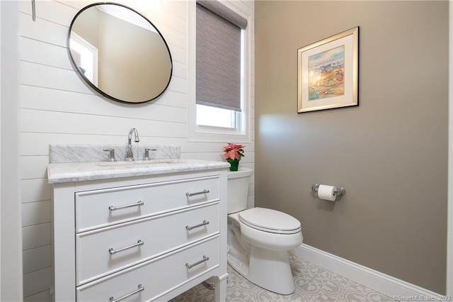 bathroom with toilet, large vanity, and tile flooring