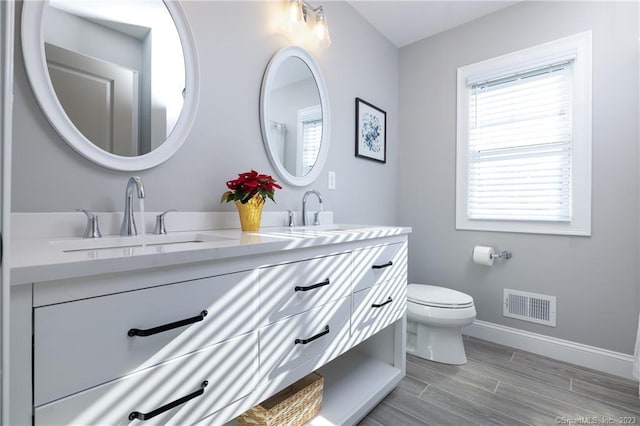 bathroom with double sink vanity and toilet